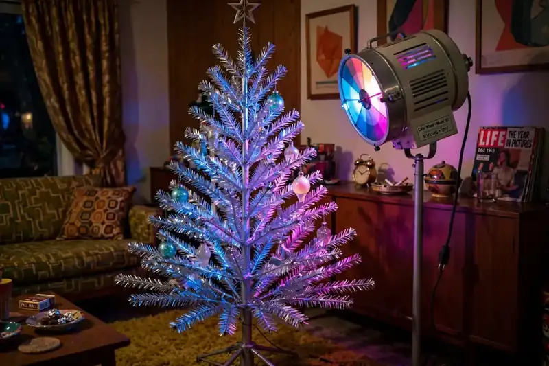 Silver aluminum Christmas tree from the 1960s lit by a rotating color wheel