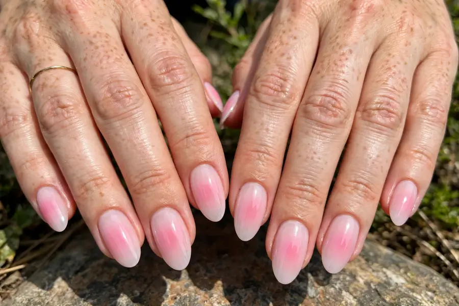 Blush aura nails on real hands with a soft pink gradient blooming from the centre