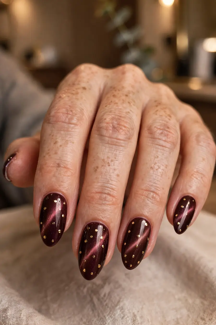Burgundy wine polka dot cat eye nails with metallic gold dots