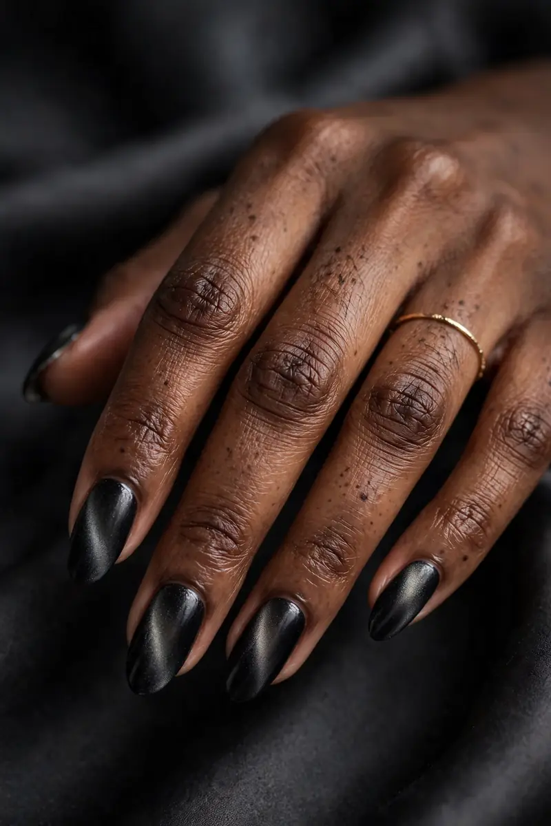 Black velvet nails with subtle smoky shimmer on real hands