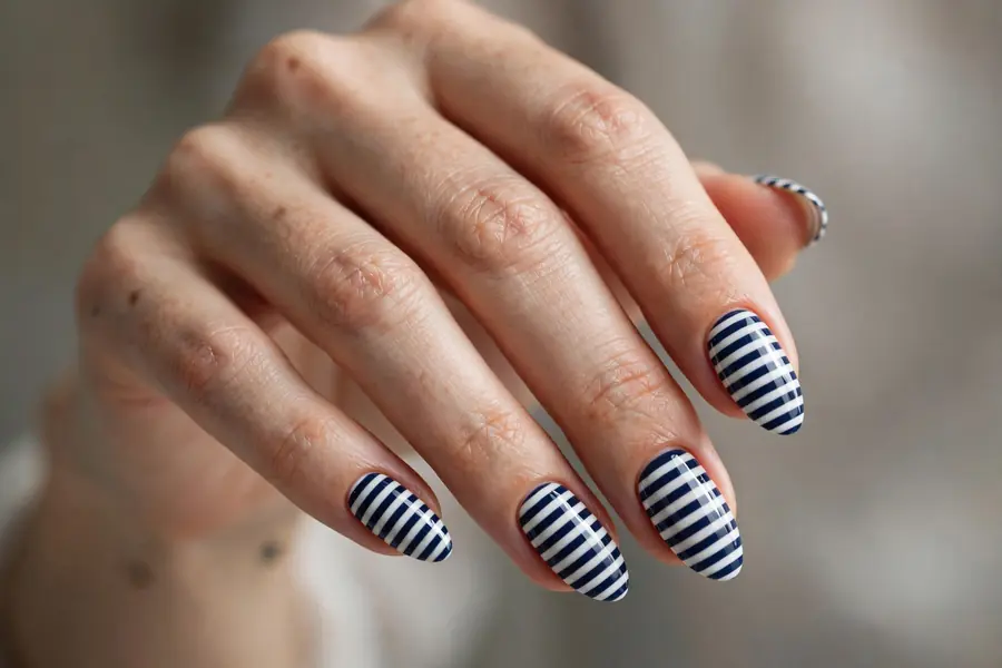 Navy and white Breton striped almond nails on real hands