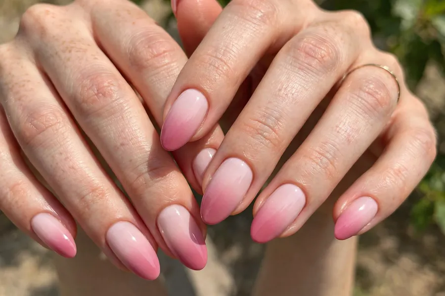 Blush ombre nails on real hands fading from pale pink to deeper rose