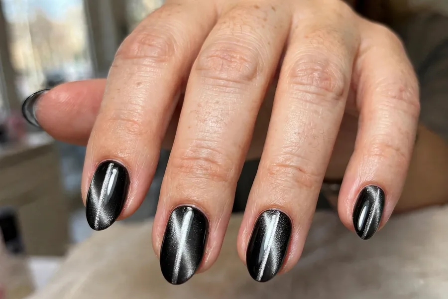 Black onyx cat-eye nails with silver shimmer