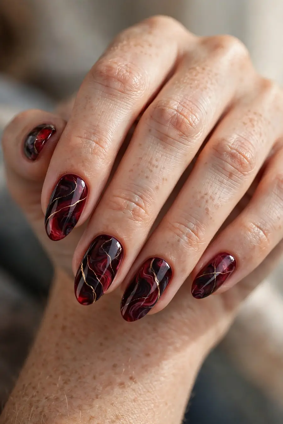 Burgundy marble nail art with garnet swirls