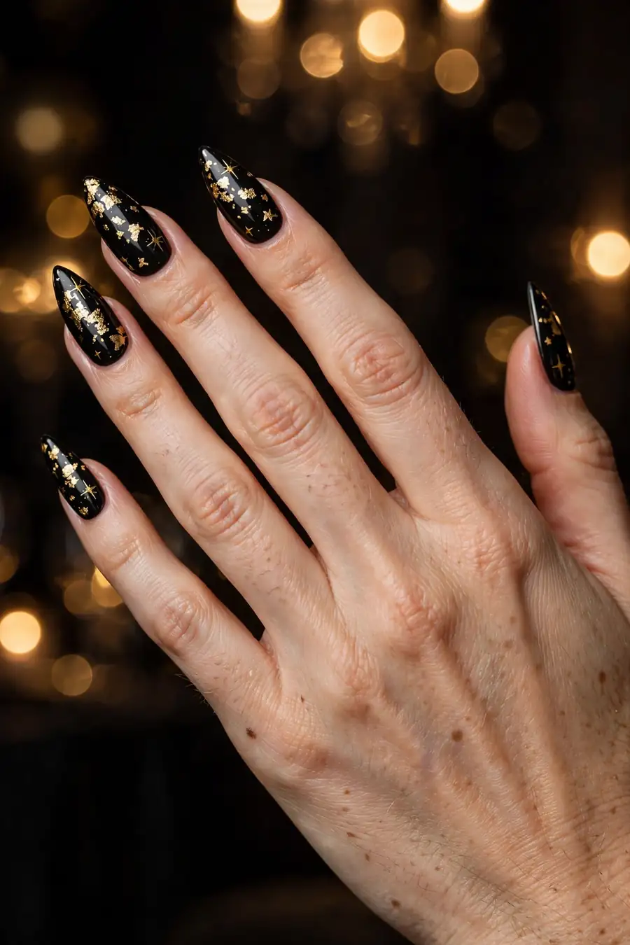 Black birthday nails with gold foil and gold stars