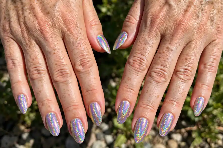 Iridescent glitter nails on real hands in bright light