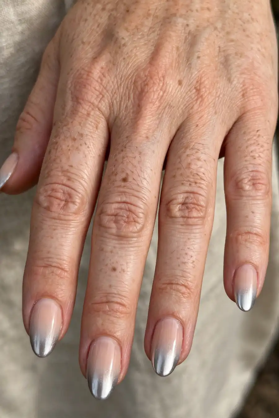 Silver ombre fade chrome nails on real hands fading from nude to silver