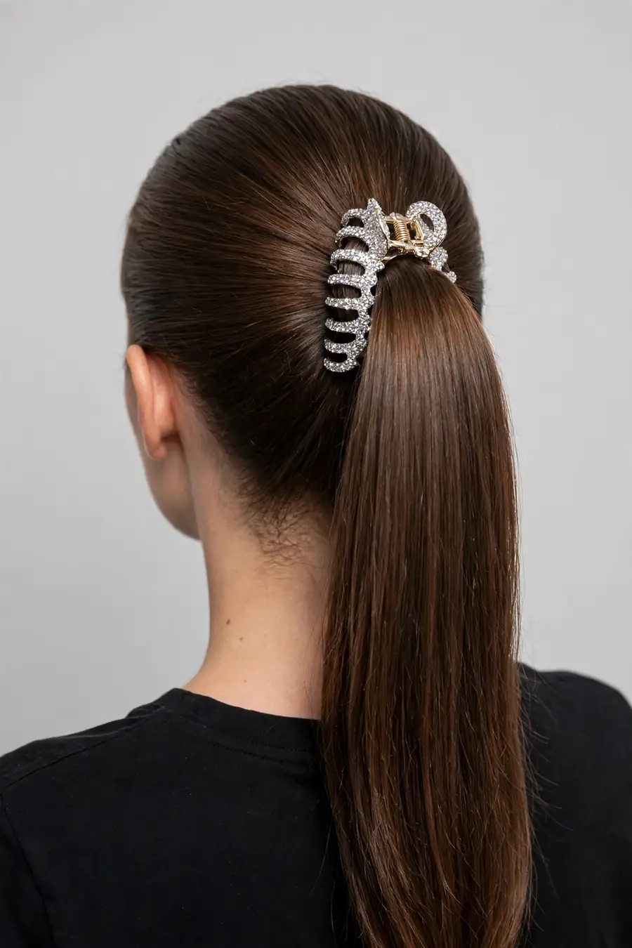 sleek high ponytail secured by a bedazzled claw clip