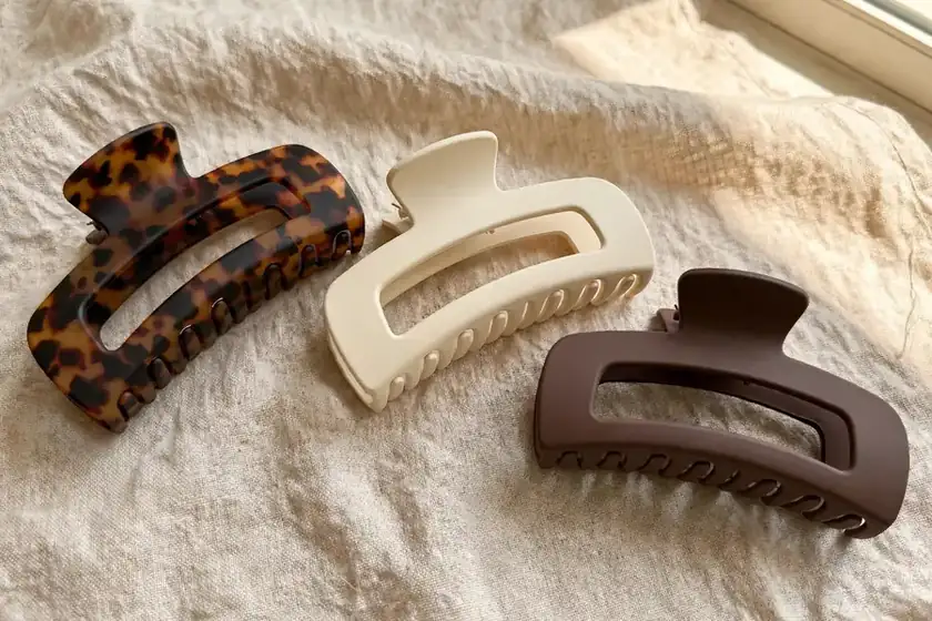 Three oversized matte hair claw clips in tortoiseshell, cream and chocolate
