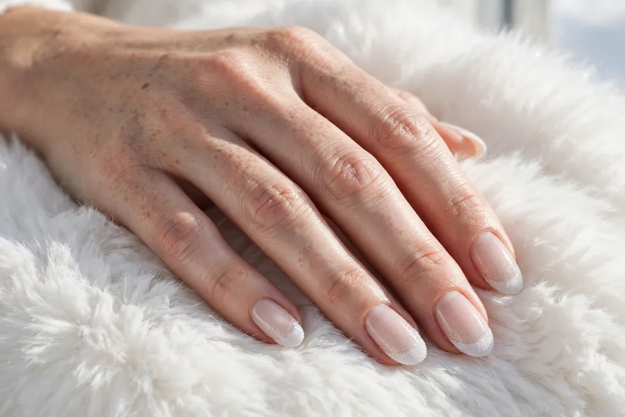 Winter white french december nail ideas with frosted shimmer tips on a sheer milky base