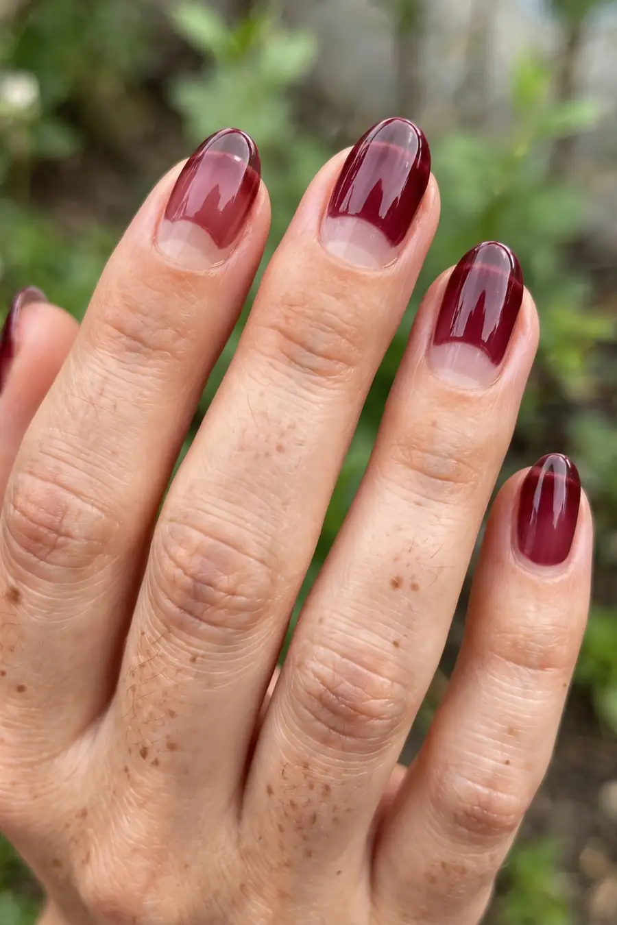 Sheer jelly burgundy nails with a wine stain effect