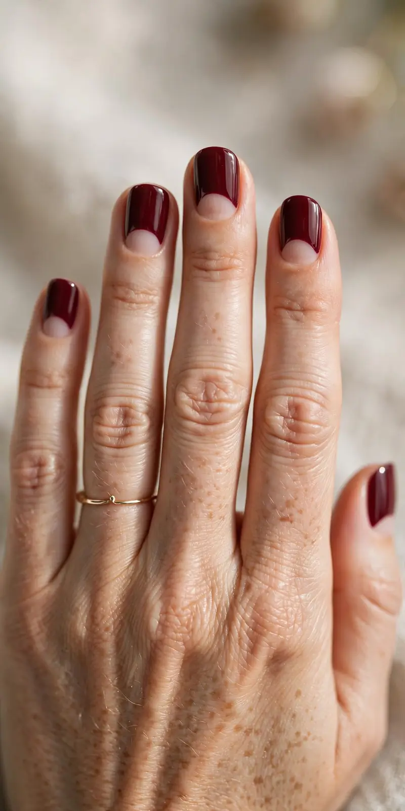 Half-moon manicure with burgundy and nude tones