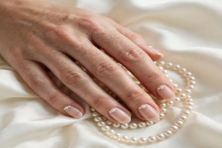 Pearl-adorned Valentine's Day nails with tiny pearls on nude