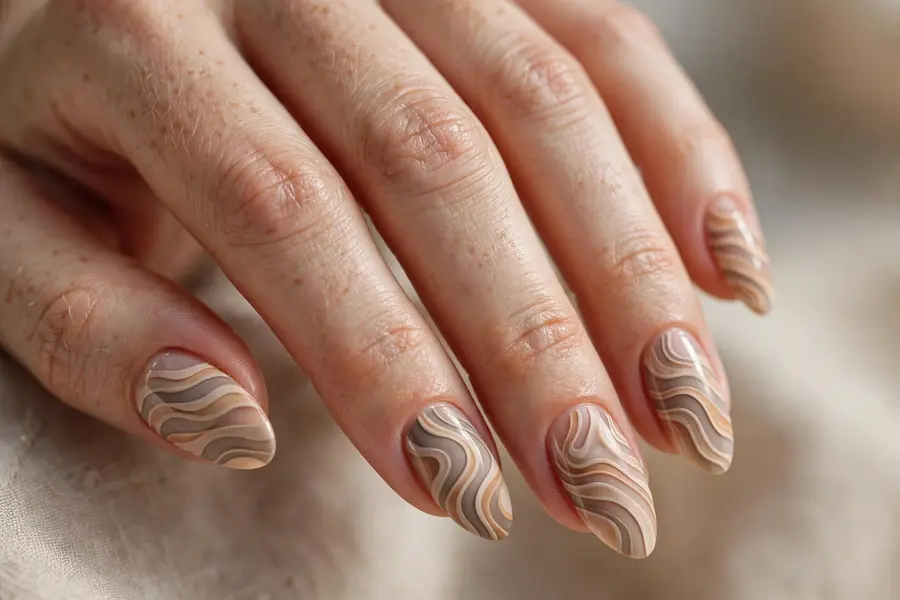 Sand dune wavy striped almond nails in beige on real hands