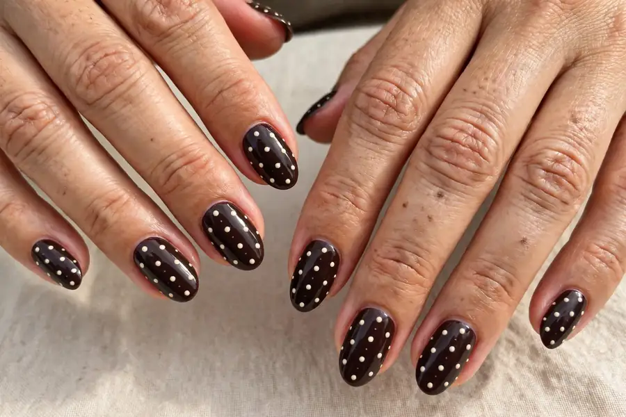 Midnight cocoa hot chocolate nails with cream dots on real hands